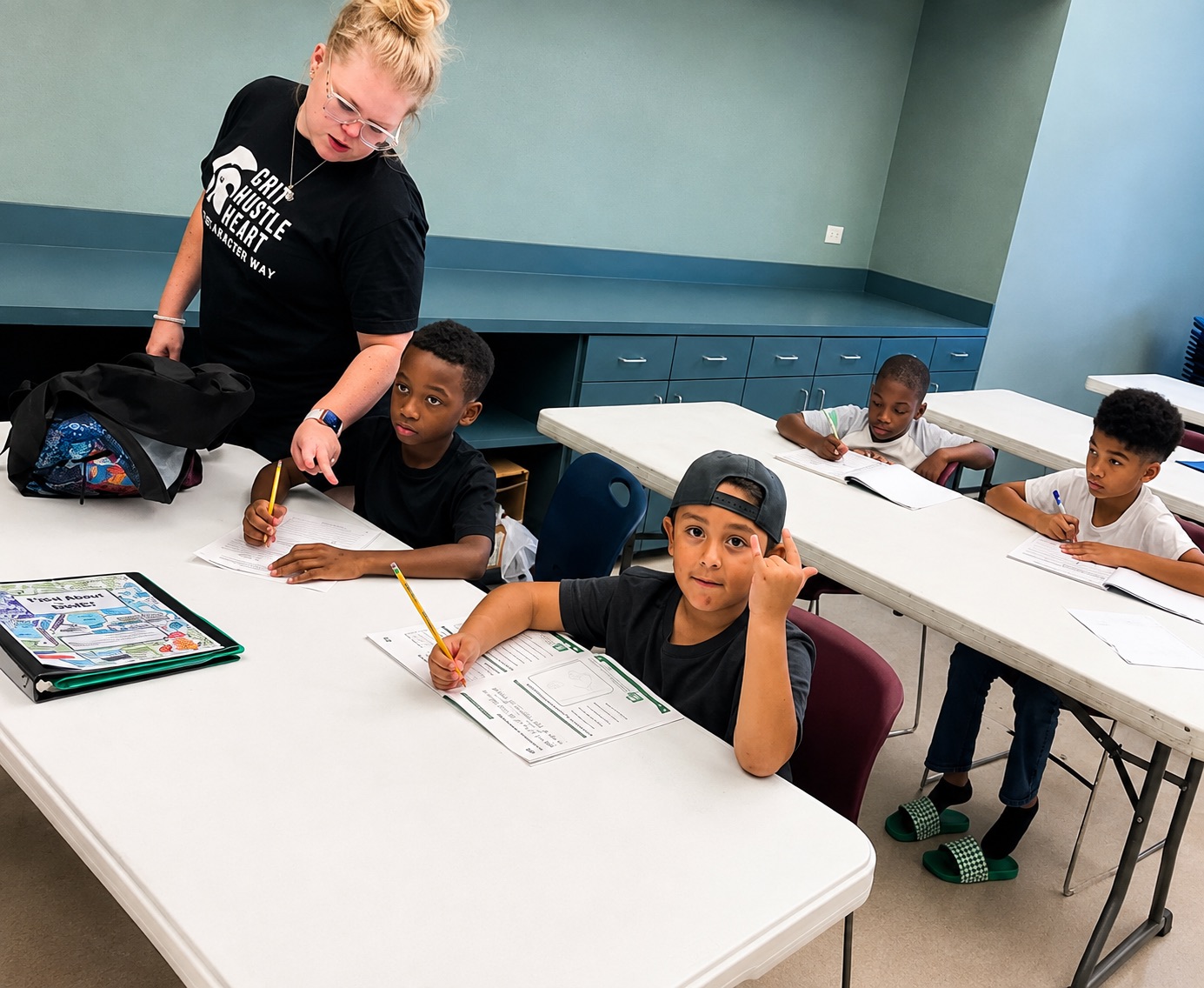 A tutor helping a young elementary school student with a reading worksheet