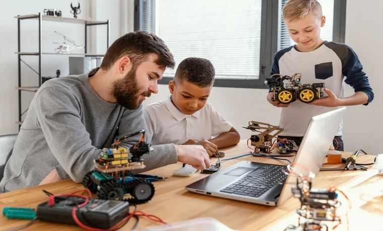 A tutor helping young students build and program small robots at a table