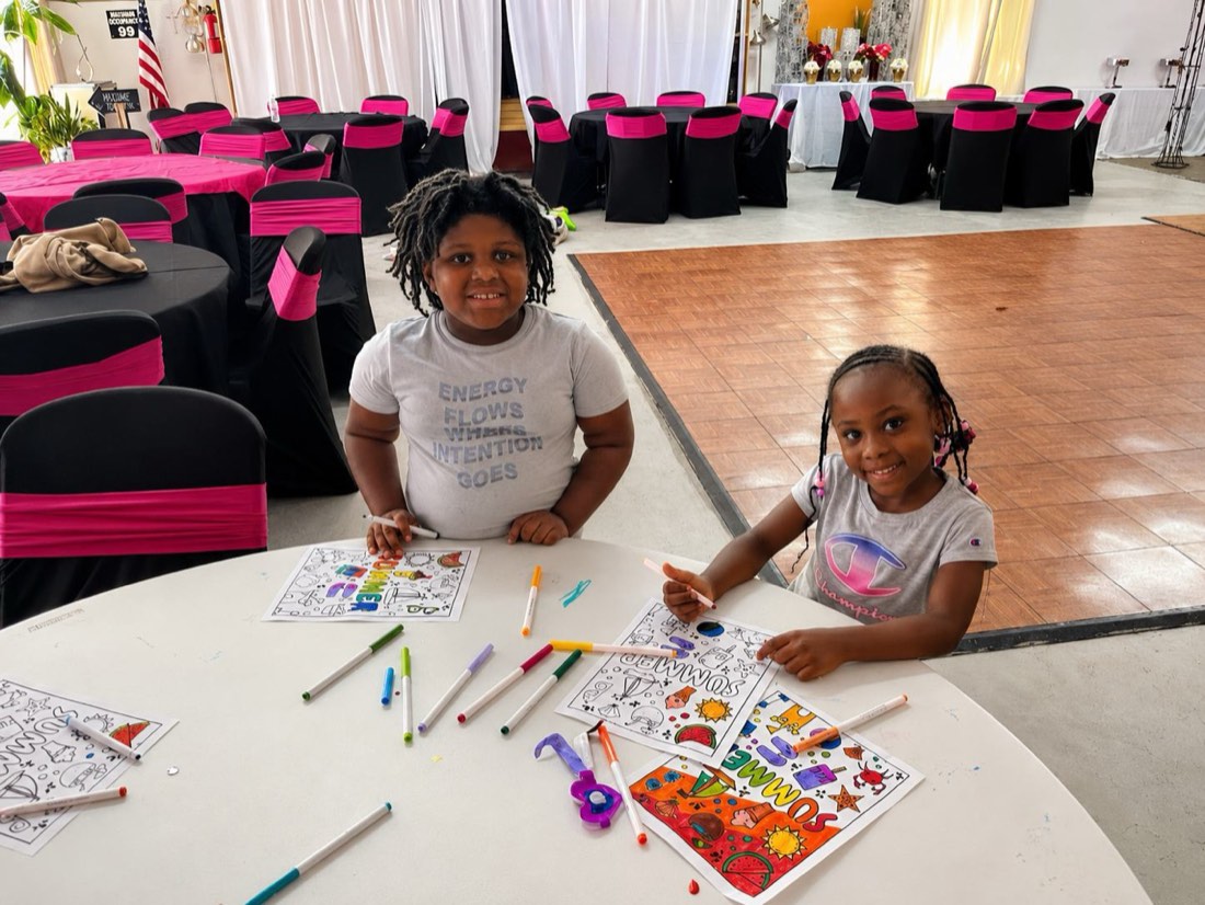 Two campers painting and drawing at a craft table